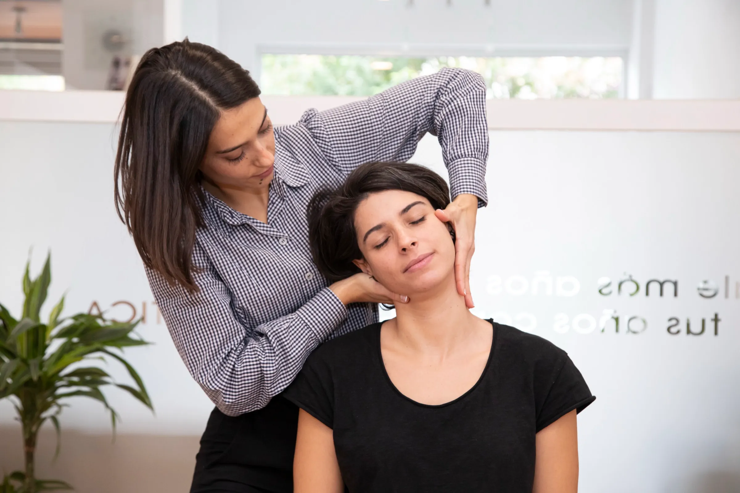 Ajuste cervical de una paciente sentada en la consulta