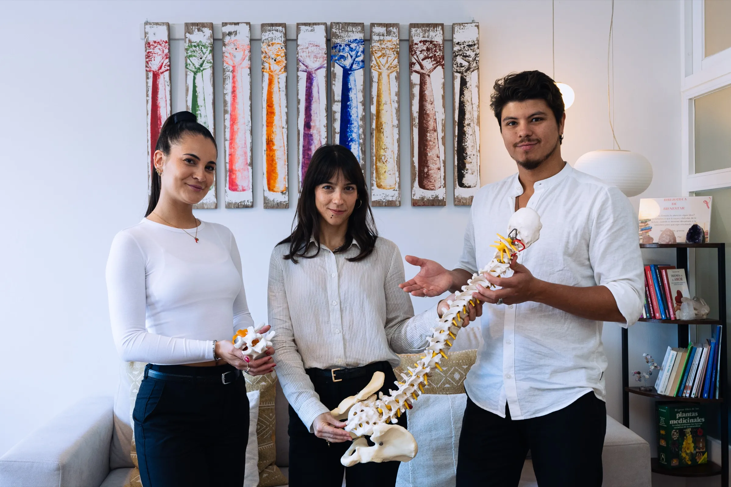 Flor, Irati García y Sebastian, el equipo del centro, con modelos de columna vertebral